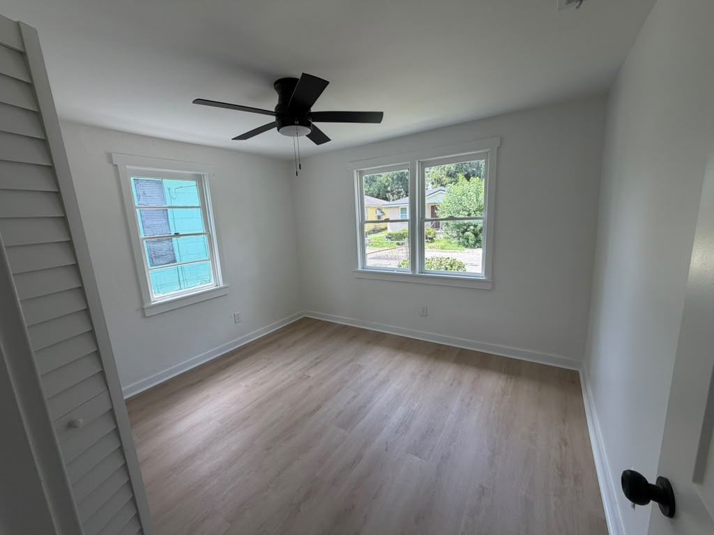 Bedroom with new flooring, fresh paint, trim and ceiling fan