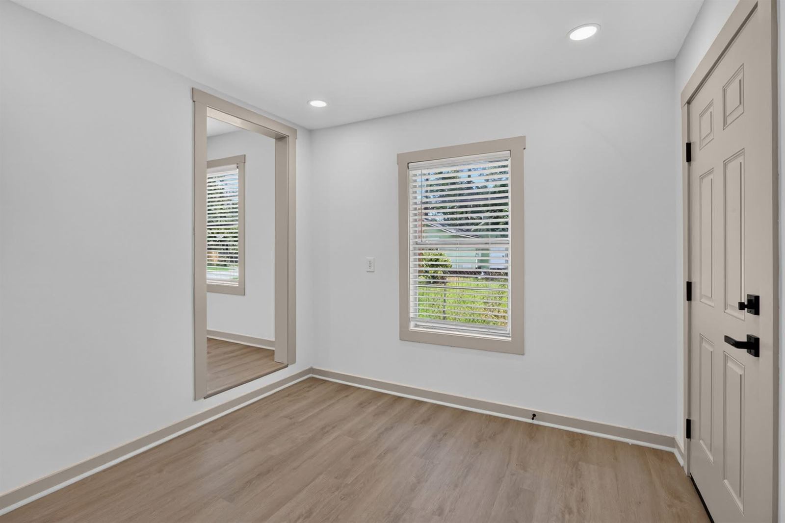 Second bedroom after renovation with new flooring and recessed lighting