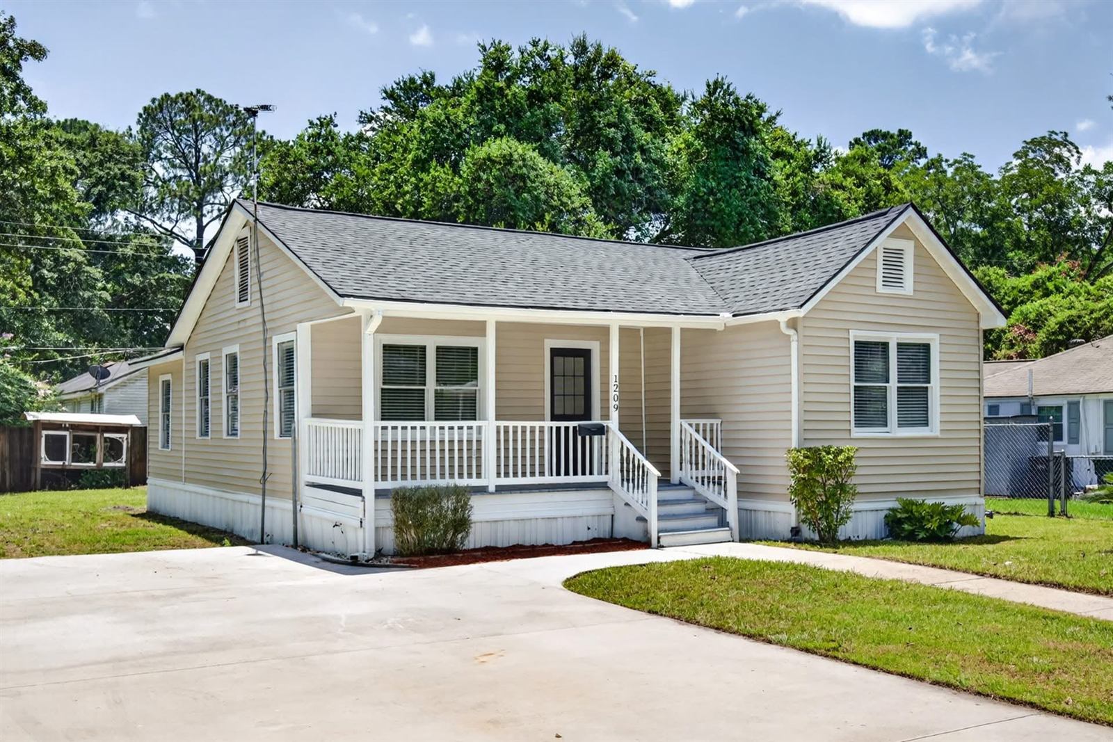 Porch bungalow in Savannah after a full renovation with new roof, repainted siding and rebuilt front porch