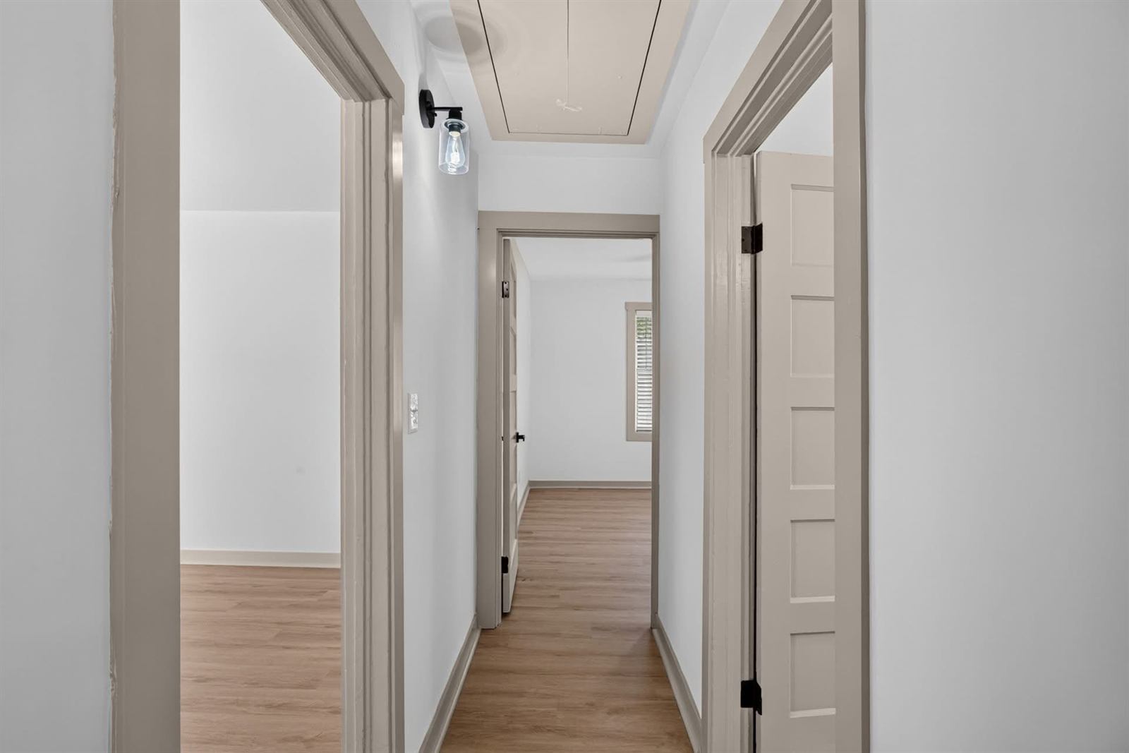 Renovated hallway with new flooring, trim and lighting